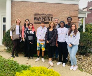 Waypoint youth stand outside the center with WFWIB Youth Services Manager.